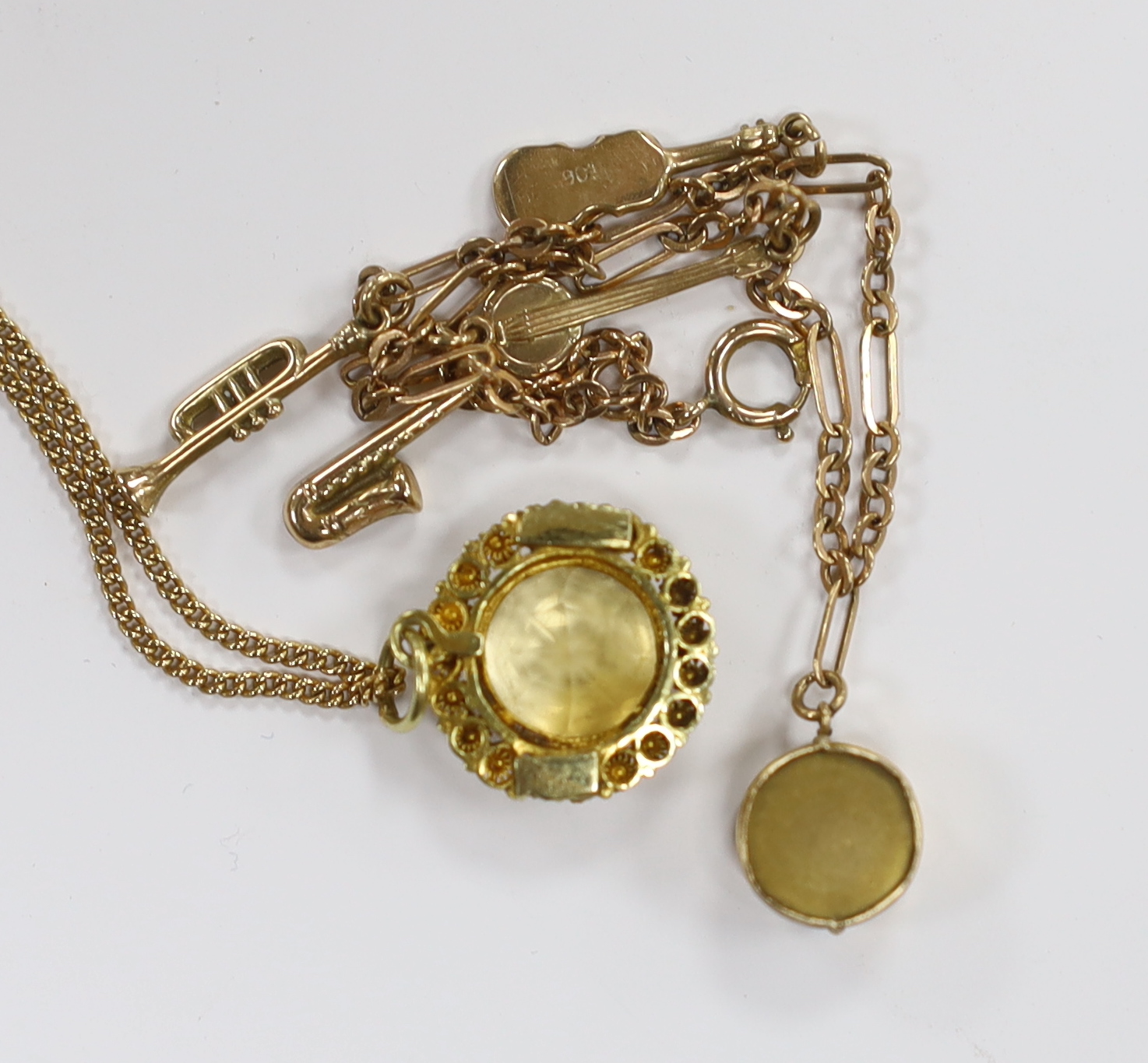 A small 9ct gold charm bracelet, hung with three assorted charms, gross weight 3 grams and a yellow metal and citrine set pendant on a 15ct chain, gross weight 5.5 grams.